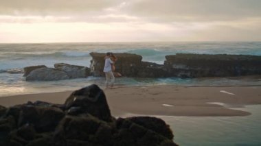 Joyful people spinning sea beach vacation together. Unknown couple showing love at nature horizon line. Attractive girlfriend boyfriend having fun enjoying holiday at ocean coast. Leisure concept 
