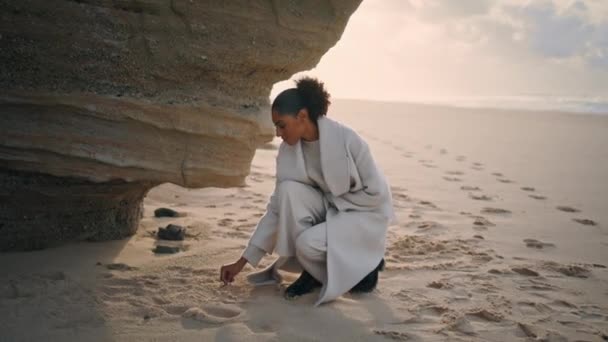 Woman Writing Beach Sand Shore Cliff Rock Black Hair Tourist — Stockvideo