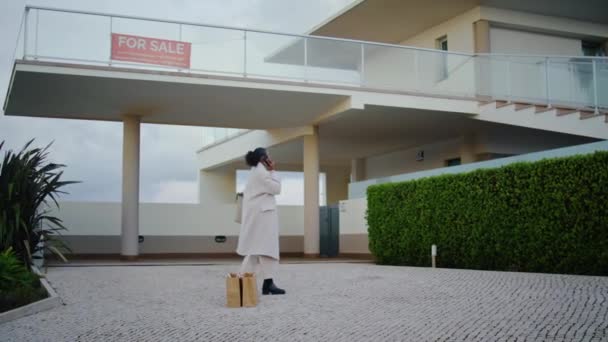 Emlakçı Kadın Telefonundan Konuşuyor Afro Amerikan Tarzı Modern Binaları Teftiş — Stok video