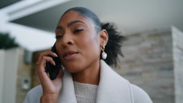 路上でスマートフォンを話す魅力的な女性がクローズアップ 深刻なアフリカ系アメリカ人の財産取引を議論する深刻な会話を持っている 不動産屋さんから電話です 裕福な上品な女性 — ストック動画