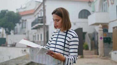 Şehir caddesindeki haritaya odaklanmış kız. Güzel bir turist kasabayı geziyor. Varış yeri arıyor. Turistik rehber okuyan düşünceli bir kadın yaz tatilinde seyahat ediyor. Avrupa gezisi kavramı