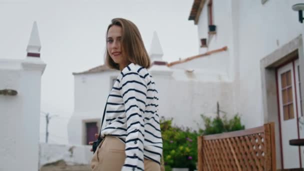 暑假走老城区的女孩 地中海粉刷建筑 接下来是美丽的游客探索城市狭窄街道的镜头 一个漂亮的女人在旅行时摆姿势观光旅游 — 图库视频影像