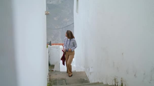 旅行者在暑期旅行中走狭窄的街道楼梯 美丽的女孩独自探索城市 享受静坐的白色房子 重点旅游摄影师漫步旧城 旅行记忆概念 — 图库视频影像