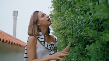 Romantik kız yapraklara dokunuyor. Doğanın tadını çıkaran güzel bir kadın. Baharda dertsiz turistlerin bahçeyi okşaması, dar sokaklarda dolaşması. Tatil gezintisi yaz kırsalında..