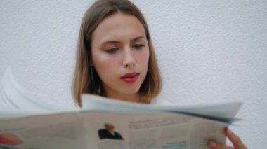 Rahat bir kız sabahları gazete okuyor. Gülümseyen kadın kameraya bakıyor ve kahvaltıda yalnız eğleniyor. Çekici iş kadını kira çeki küresel finans haberleri sunuyor. Günlük rutin kavram.