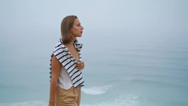 一个女孩独自在悬崖顶上走海景 心烦意乱的年轻女子在思考人生的危机 宁静的游客在户外享受夏日海风的放松 去海滨旅行的漂亮女士 — 图库视频影像