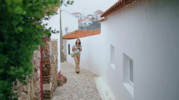 欧洲度假时 年轻的游客在街上散步 重点女孩举行相机探索古老的冥想城市在周末 无忧无虑的女性博客写手夏天欣赏白色建筑 — 图库视频影像