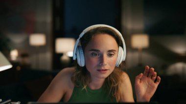 Ofiste bilgisayarla sohbet eden odaklanmış bir kız. Mutlu kulaklıklı kadın dizüstü bilgisayarını kapatıyor. Yetenekli serbest yazar iyi ruh hali içinde şarkılar dinliyor. Doğal güzellikteki kadın dijital cihazla meşgul.