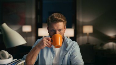 Uzak bir iş yerinde cappuccino içen ciddi bir serbest yazar. Akıllı adam gece ofisindeki bilgisayar monitörüne bakıyor. Sakallı adam çay içiyor ve bilgisayar izliyor. Fazla mesai konsepti 