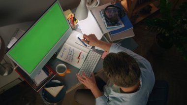 Bilinmeyen adam üst görünümü not alıyor. Ginger Freelancer uzaktan kumandayla çalışıyor. Kimliği belirsiz bir adam evde internete göz atıyor. İşkolik kişi gece geç saatlere kadar çalışıyor.