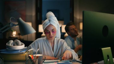 Odaklanmış muhasebeci eve zoom yapıyor. Ciddi kadın, hesaplama bütçesini yakından hesaplıyor. Serbest çalışan kız akşamları uzaktan klavye ile haftalık rapor hazırlıyor. Erkek silueti şarkı söyleme kurutucusu