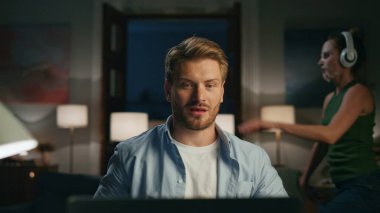 Muzaffer adam yakın planda bilgisayarla sohbet ediyor. Gülen adam ekranı saklıyor. Komik kadın silueti oynaşıyor. Gülümseyen serbest yazar evde video görüşmesi yapıyor. Uzak çalışma dezavantajları konsepti 