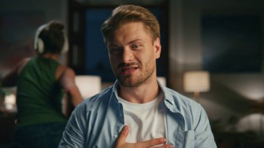 Sinirli bir adam karanlık odada bilgisayarı rahatsız etti. Kızgın adam kendini rahatsız hissediyor. İşsiz eş silueti arka planda rahatsız edici bir şekilde dans ediyor. Fazla mesai yapan serbest yazar görüntülü sohbette bahaneler uyduruyor