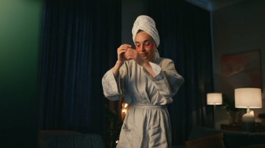 Aktif serbest çalışan, bilgisayarla konuşan, yakın çekim. Bornozcu kadın monitör görüntüleme cihazı akşam görüntüsü veriyor. Sanal bilgisayar akışına uzaktan el kol hareketi yapan duygusal blogcu. Yaratıcı insanlar