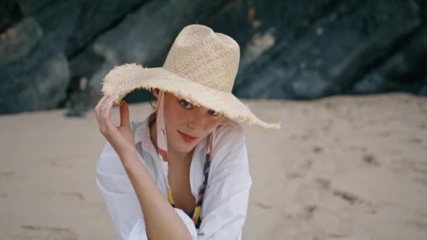Mujer Hermosa Juguetona Sombrero Paja Sentado Arena Playa Mirando Cámara — Vídeos de Stock