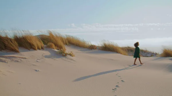 砂の上に足跡を残し夏の砂漠を歩く未知の少女 アフリカ系アメリカ人女性のシルエットが黒いドレスを着て砂丘を踏んでいる リラックスした女性は美しい荒野の自然を楽しむ — ストック写真