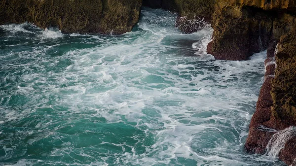 夏にはターコイズブルーの海の泡の崖 寒い日に岩の多い海岸線を洗う青い深い水 劇的な海の波が海岸で山を壊すクラッシュします 危険な素晴らしい自然の美しさの概念 — ストック写真