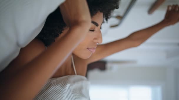 放松的女士伸展在早晨床的特写镜头 睡眠不足的女孩在柔软的枕头前醒来 非洲温文尔雅的相机 享受着健康的睡眠 安详的女人睡在新鲜的床垫里 — 图库视频影像