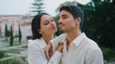 Sevecen insanlar parkta romantik randevulara sarılıyorlar. İspanyol kadının seksi erkek arkadaşını öpmesi. Gülümseyen tatmin olmuş bir adam. Sevgi dolu çift birlikte rahatlarken şefkat gösteriyor. Sevgililer hafta sonunun tadını çıkarıyor