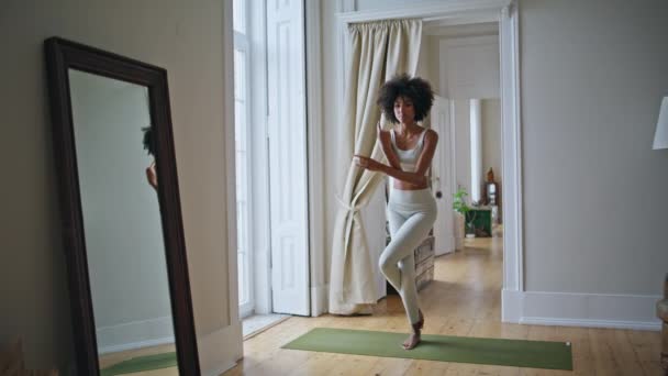 マットでヨガアサナを練習スリムモデル カーペットで運動をするアフリカのフィット女性 白い部屋で柔軟な巻き女性のトレーニングバランス瞑想 調和のとれたアクティブライフスタイルコンセプト — ストック動画