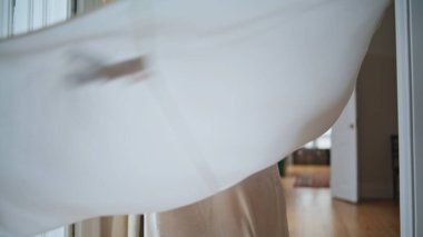 Dancing lady swirling home closeup. Unknown woman in silk robe having fun at cozy apartment. Happy girl spinning alone at morning house. Excited female person celebrating weekend at beige interior