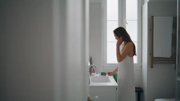若い女性がバスルームで髪をブラッシング シャワーだけで保湿マスクを施した女子 朝のアパートのインテリアに鏡を見て官能的な女性 国内の美しさ ルーチンとケアコンセプト — ストック写真