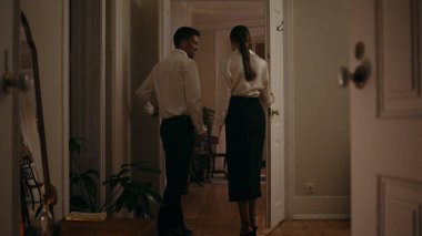 Gentle man inviting woman at romantic evening room. Interested lady watching candles table interior. Loving couple celebrating anniversary at cozy home. Married sweethearts walking to dining place