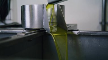 Tesisteki basınçlı yağ akış borusu kapanıyor. Yiyecek fabrikasında ekstra lezzetli, saf sıvı sıkma makinesi. Kapalı alanda zeytin altından bir ürün çıkarma işlemi. Üretim hattının son aşaması