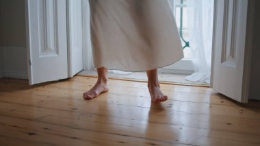 Tender woman legs stepping at morning home closeup. Unknown girl moving at wooden floor interior. Calm lady feet dancing at cozy apartment alone. Anonymous female person enjoying big window view