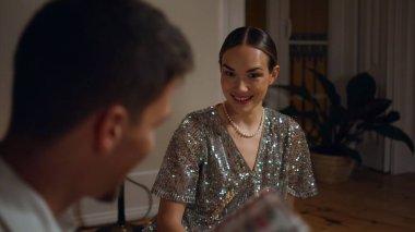 Surprised woman getting gift at xmas celebration closeup. Happy pair exchanging presents at evening room. Brunette man greeting birthday lady indoors. Smiling couple sitting floor at party night