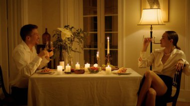 Yeni evlilere gülüp evde şarap kadehi içiyorlar. Gülümseyen adam romantik bir randevu sırasında kadının duygusal konuşmalarını işaret ediyor. Neşeli aşıklar birlikte servis edilen mumlarda eğleniyorlar.