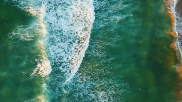 無人偵察機は未知の歩行者とターコイズブルーの海の波砂のビーチを洗う撮影 夏の日当たりの良い夏の遅い動きに泡立つ美しい海のうねり シネマティックな空撮海岸風景 — ストック動画