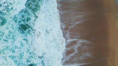 Mavi deniz suyu tropikal kumsalda yavaş çekimde çarpışır. Sinematik hava manzaralı fırtınalı okyanus dalgaları deniz kıyısında köpürüyor. Resimli deniz manzarası. Deniz kıyısında dalgalanan güçlü dalgalar..