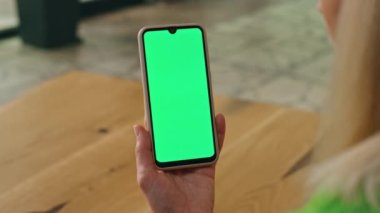Yönetici, ofisteki yeşil ekran telefona dokunuyor. Kapalı mekanda tek başına kromakey cep telefonu görüntüsü çalan anonim bir kadın. İş kadını elleri iş yerinde kayan cep telefonu. 