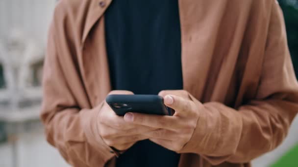 男の指公園の閉鎖でスマートフォンをテキストメッセージ 春の自然で現代的なデバイスを使用してメッセージを入力してカジュアルなビジネスマンの手 公衆の場で携帯電話の仕事をしてる無名の男 コミュニケーションの概念 — ストック動画