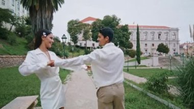Bahçe yolunda koşan evli bir çift. Pozitif erkek kadın yaz doğasında el ele tutuşup eğleniyor. Heyecanlı, neşeli sevgili birlikte gülüyor, parktaki romantik buluşmanın keyfini çıkarıyor.