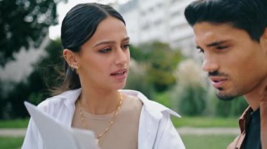 Latin çift açık havada doküman okuyor. Ciddi iş adamları göğüs portresi üzerinde birlikte çalışıyorlar. Spring Park 'ta çalışan zeki iş arkadaşları. Esmer kadın iş arkadaşıyla konuşuyor.