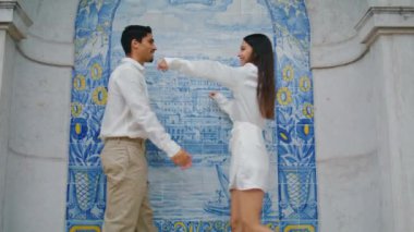 Seramik fayanslar içinde kucaklaşan sevgi dolu yeni evliler. İspanyol romantik çift Azulejo duvarında birbirlerine sarılıyorlar. Mutlu erkek kadın duygularını birlikte ifade ediyor. Genç kaygısız aşıklar buluşmanın tadını çıkarıyor.