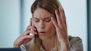 Stresli girişimci, çalışma odasındaki telefonu kapatıyor. Ofis portresi çekilirken iş problemlerini çözerken şok oldum. Kafası karışmış iş kadını kabinede facepaling yapıyor. Proje krizi konsepti 