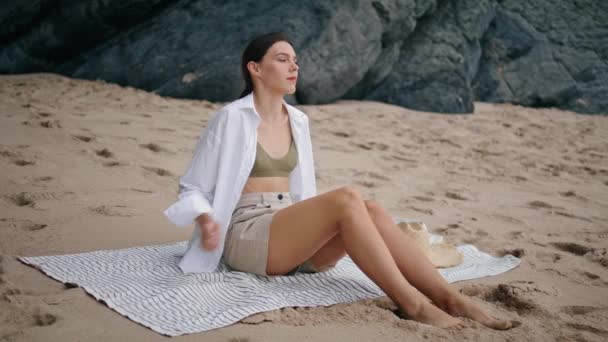一个寂寞温柔的女人坐在沙滩上 看着海景 迷人的小女孩穿着白衬衫 光着脚躺在沙滩上 在被子里放松一下 漂亮的女士享受平静的暑假 — 图库视频影像