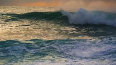 Sabah dalgaları fırtınadan önce dalgalanır. Güçlü beyaz dalgalar çok yavaş çekimde yüzeysel bir şekilde dönüyor. Çarpıcı Pasifik manzarasında devasa dramatik okyanus akıntısı. İnanılmaz doğa deniz manzarası konsepti