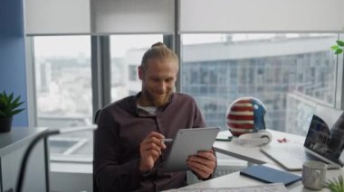 Dijital Tablet Ofisi 'nde Stylus' u boyayan olumlu bir adam var. Uzaktan kontrol edilen iş yerinde kalem kullanan profesyonel web tasarımcısı. Modern dairede resim oluşturan grafiksel çizimci