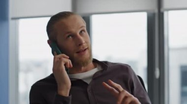 Kendine güvenen serbest çalışan ev ofisinden cep telefonunu arıyor. Sakin tasarımcı, hipster apartman portresindeki telefonu açıklıyor. Akıllı telefonu tutan yakışıklı iş adamı yalnız çalışıyor. Teknoloji konsepti 