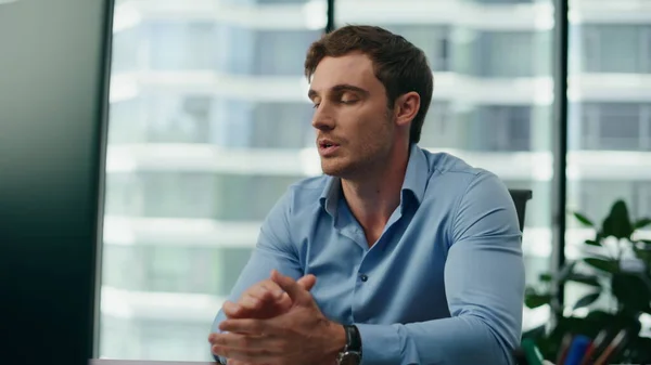 stock image Serious man conducting video conference sitting desk with modern computer close up. Portrait of tired professional manager communicating by internet call in office. Young businessman working online.