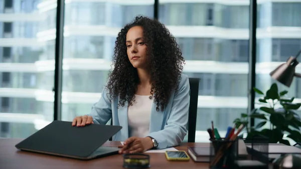Depressed businesswoman opening laptop starting work in company office close up. Curly latin american woman manager preparing to tipe financial report on computer. Technology in corporate life concept