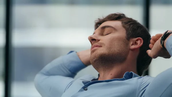 Director stretching body at office closeup. Satisfied man having break alone. Young employee enjoy job achievement. Businessman relaxing dreaming with calm expression. Comfort at workplace concept