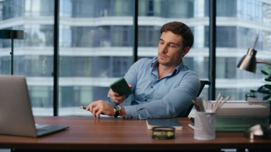 İş yerinde akıllı telefonları açan yakışıklı bir iş adamı. Ciddi bir yönetici panoramik pencere ofis içinde cep telefonuyla konuşuyor. Kendine güveni tam bir iş adamı. 