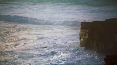 Fırtına dalgaları kıyıya vuruyor. Köpüklü okyanus sıçraması kayalık kıyı şeridini yıkıyor. Güçlü deniz dalgaları vahşi volkan sahillerini vuruyor. Çarpıcı taş kıyı şeridi. Olağanüstü deniz manzarası konsepti.