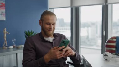 Masada gülümseyen daktilo öğrencisi. Blue Wall Apartmanı 'nda e-posta okuyan, akıllı telefonları dinlendiren pozitif bir serbest yazar. Sakin adam cep telefonu mesajı yazıyor. Büyük pencerelerde iş yerinde mola veriyor.