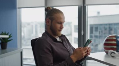 Düşünen adam hipster odasında cep telefonunu kontrol ediyor. Sakin, genç görünümlü pencereler şehir manzaralı dairede akıllı telefon tutuyor. Ciddi bir yönetici modern ofiste tek başına bir mesaj yaratıyor.